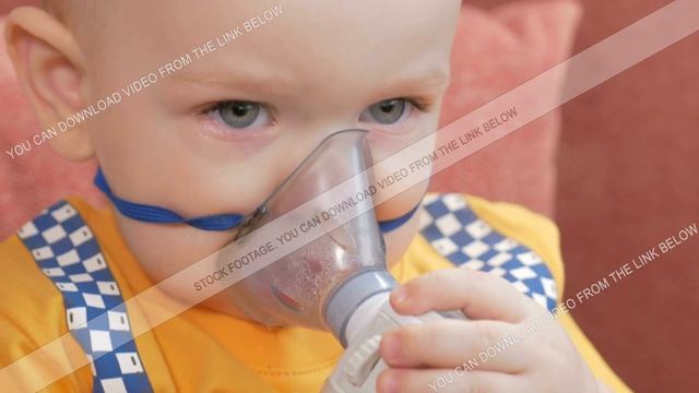 The kid himself holding a mask from an inhaler and breathes the medicine at home. Treats