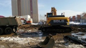 Экскаватор копает котлован для высотного дома