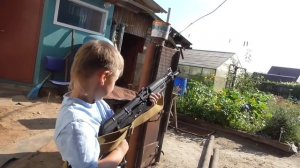 Страйкбольный автомат АК 105 в руках ребёнка.