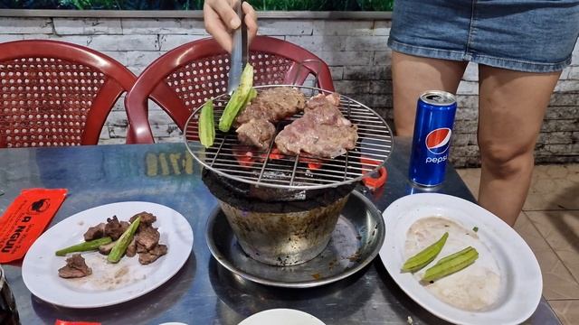 Вьетнамка жарит мясо в кафе