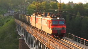 ВЛ11-343/341 А с грузовым поездом следует по мосту через реку Реж