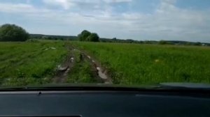 Тойота Рав 4 четвёртого поколения по бездорожью в поле после дождя.