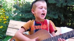 маленький мальчик играет на гитаре