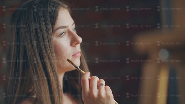 Young woman painter stands in front of window with sketches of works смотреть онлайн