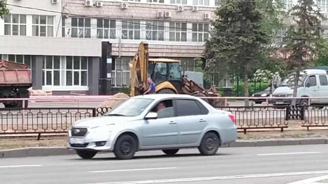 Трактор с ковшом и с отвалом работает в Академгородке города Волгоград, 4k, исходник смотреть онлайн