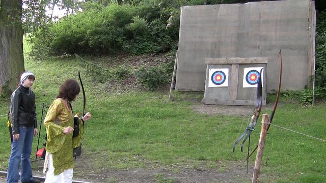 Девочка учится стрелять из лука