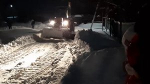 Трактор чистит снег возле дома  молитвы