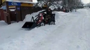 мини-трактор погрузчик минитрактор в работе, уборка снега