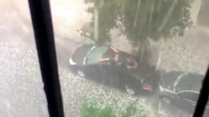 Мужик на крыше машины. Град.