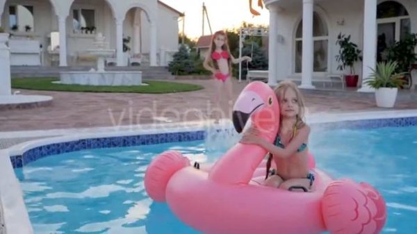Little Girl In Swimsuit Jumping Into Summer Poolside, Pretty Child in Inflatable Flamingo Swim i...