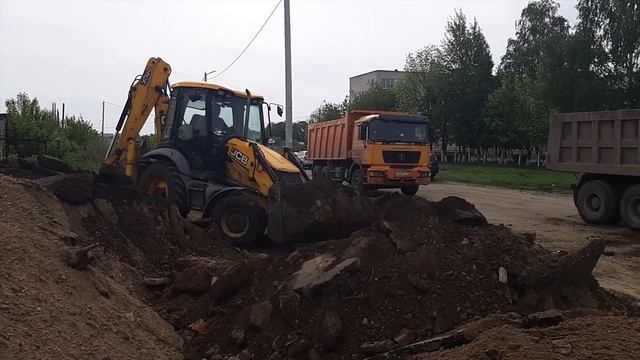 Погрузка грунта экскаватором-погрузчиком JCB в самосвалы смотреть онлайн