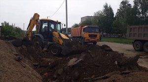 Погрузка грунта экскаватором-погрузчиком JCB в самосвалы