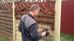 Покраска секции декоративного деревянного забора краскопультом