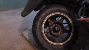 Спускает колесо, замена задней резины на скутере.