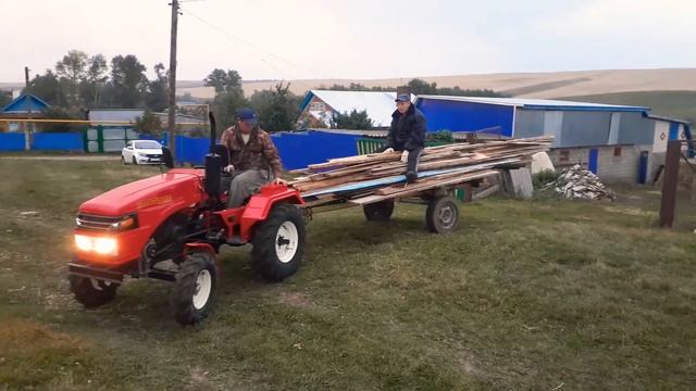 Русич-т18 в работе. Минитрактор перевозит длинные доски на самодельном прицепе. смотреть онлайн