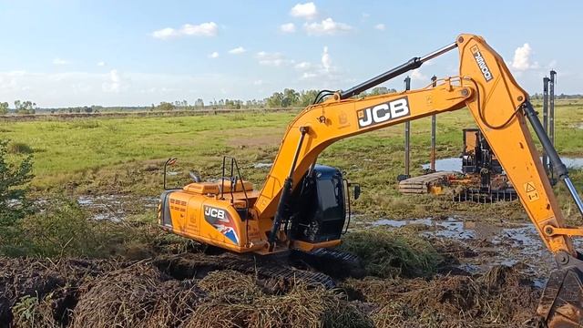 JCB Js. 200 SC removes weeds and debris from swamps Excavator смотреть онлайн