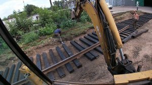 Снимаю слой грунта, укладываем шпалы, рельсы и щебень экскаватором-погрузчиком.