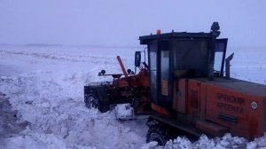 Грейдер буксует в снегу.Слетел с трассы.