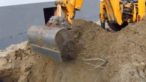 Экскаватор JCB 4CX копает приямок планировочным ковшом