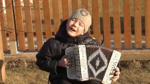 Мальчик играет на гармошке и поёт