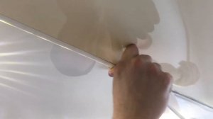Вставляем резиновую заглушку в щель разделительного профиля натяжного потолка в зале. Тольятти.