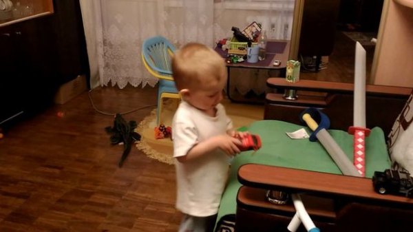 Маленький Тема (2 года) играет с мечем, саблей и машинками.