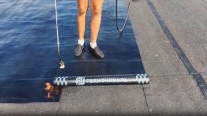 Раскатка рулона нижнего слоя «Технониколь» на старое покрытие.