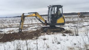 Миниэкскаватор Wacker Neuson копает мерзлый грунт под проклыдку кабеля
