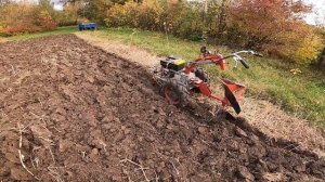 Мотоблок пашет суглинок оборотным плугом. The tiller plows loam with a reversible plow.