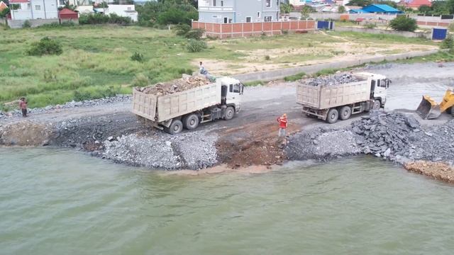 Continuing the process, a wheel loader is being used to push and move stones towards deeper waters! смотреть онлайн