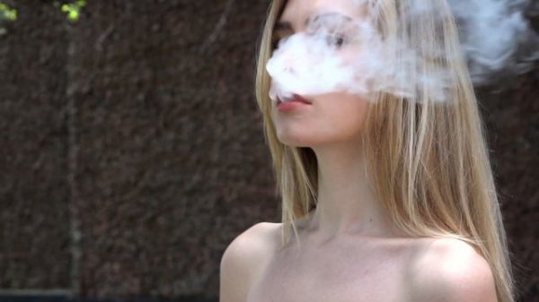 Девушка выдыхает дым.Слоумошин 100 кадров в сек.