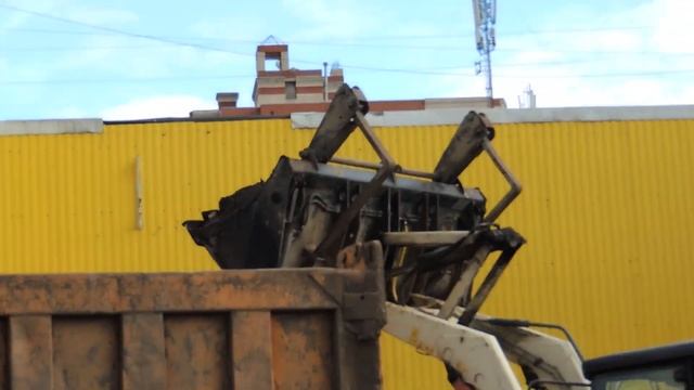 Белый экскаватор погрузчик загружает землю в Самосвал возле Магазина смотреть онлайн