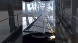 Машины ездят через железнодорожный мост