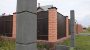 Быстровозводимый забор из бетонных столбов и плит.