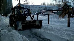 Трактор чистит снег