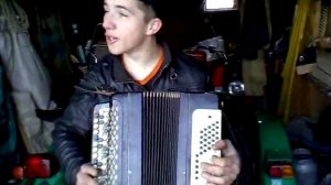 парень играет на гармони в гараже