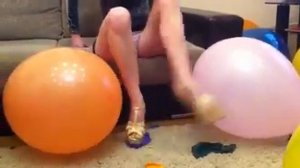 Девушка лопает шарики каблучками