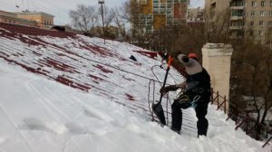 Чистим скатную крышу с ограждением и снегозадержателями.