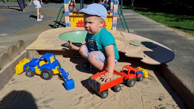 Funny Bulat A child plays in the sandbox with a tractor and transports sand in a cart смотреть онлайн