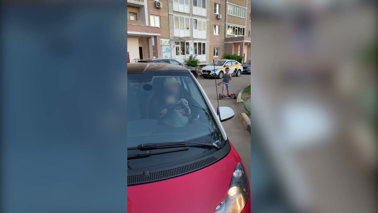 Женщина на автомобиле развлекает ребёнка во дворе многоквартирного дома смотреть онлайн