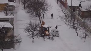 Машина буксует в снегу, нереальные сугробы. Застряли две машины. Девушка толкает автомобиль.