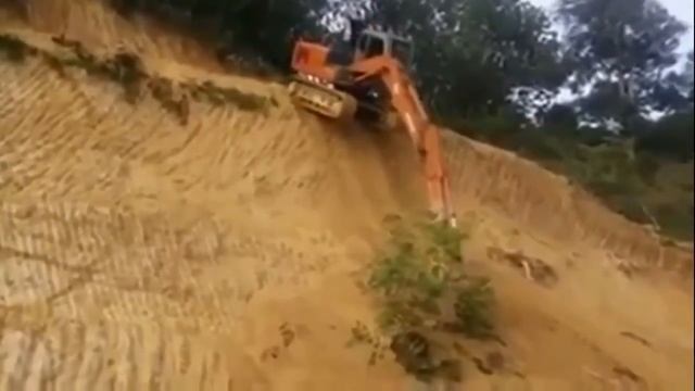 Экскаватор спускается по совершенно отвесному склону
