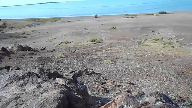 На вершине сопки с камнями костровища битые стёкла, а вид на озеро Балхаш и город хорошие смотреть онлайн
