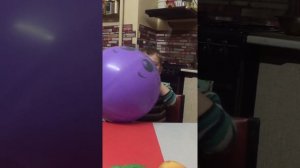 Ребёнок надувает шар