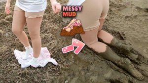 Девушка в бежевых колготках и белых носочках ходит по грязи