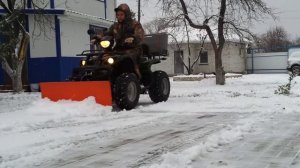 Квадроцикл чистит снег