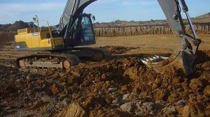 Экскаватор в Калуге грузит глиной самосвалы