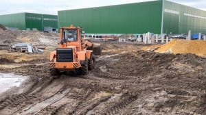 Фронтальный погрузчик АМКОДОР 332В работает на стройплощадке расчищает дорогу ООО "АСС" город Москв