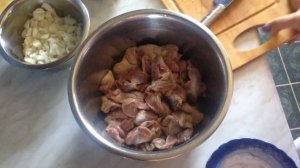 Куриные желудки тушенные на сковородке с луком и морковью.