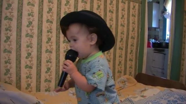 Ева с микрофоном в шляпе весело поет песни. смотреть онлайн